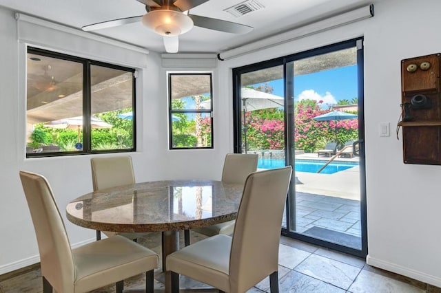 dining area with ceiling fan, a wealth of natural light, and light tile patterned flooring