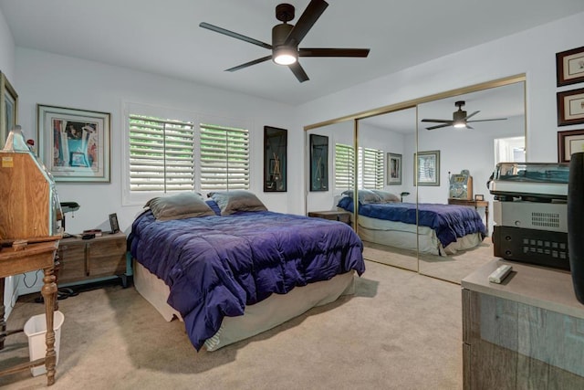 bedroom featuring ceiling fan, a closet, and light carpet