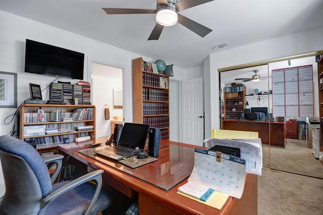 carpeted office space featuring ceiling fan