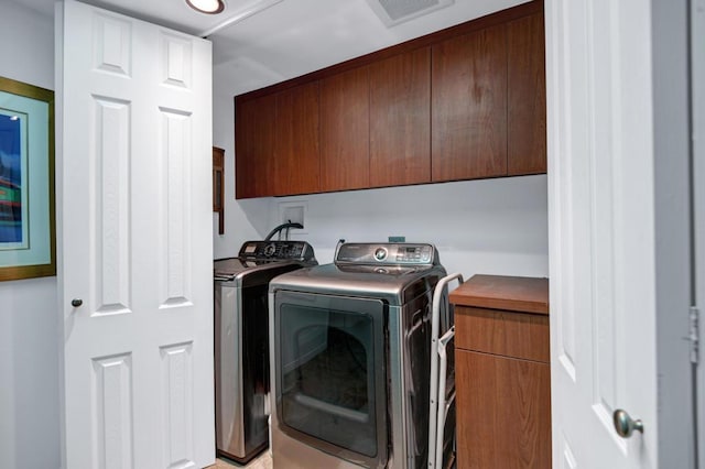 laundry area featuring cabinets and washing machine and clothes dryer