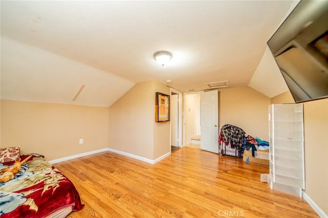 additional living space with wood-type flooring and lofted ceiling