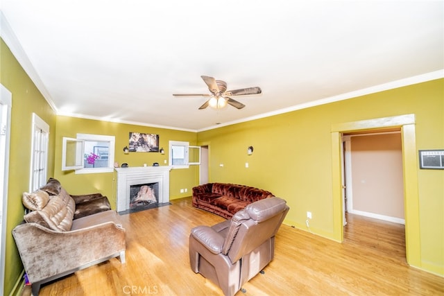 living room with light hardwood / wood-style flooring, ceiling fan, and crown molding