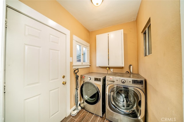 laundry room with washer and clothes dryer, cabinets, and hardwood / wood-style floors