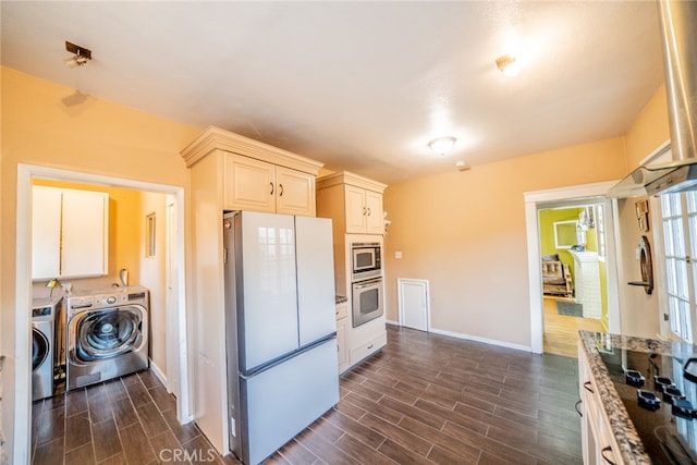 kitchen featuring dark stone countertops, appliances with stainless steel finishes, separate washer and dryer, and dark hardwood / wood-style flooring