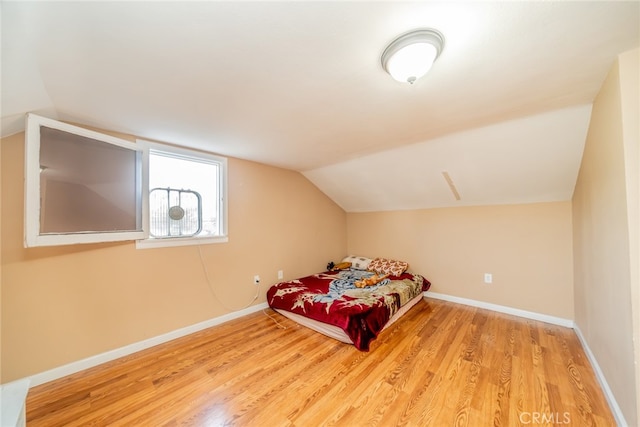 bedroom with lofted ceiling and light wood-type flooring