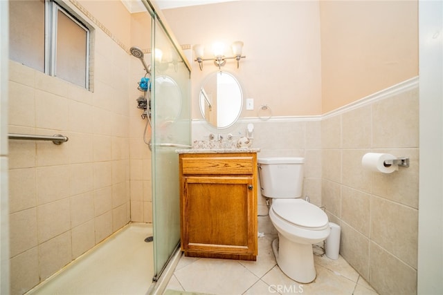 bathroom featuring vanity, tile patterned flooring, a shower with shower door, tile walls, and toilet