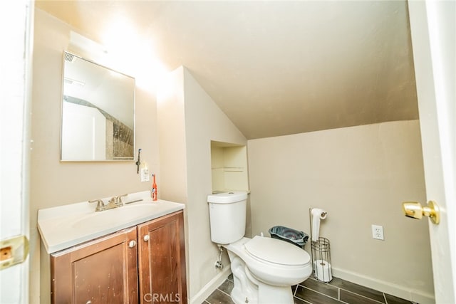 bathroom featuring lofted ceiling, hardwood / wood-style floors, vanity, and toilet