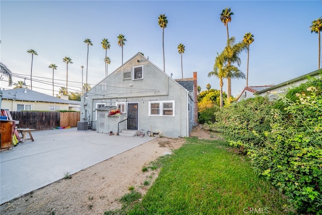 rear view of house featuring a patio area and a yard