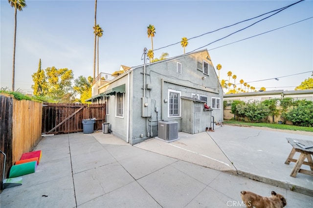 rear view of property featuring central AC unit and a patio area