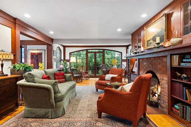 living room featuring a brick fireplace and light hardwood / wood-style floors