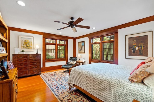 bedroom with ceiling fan, light hardwood / wood-style floors, and multiple windows