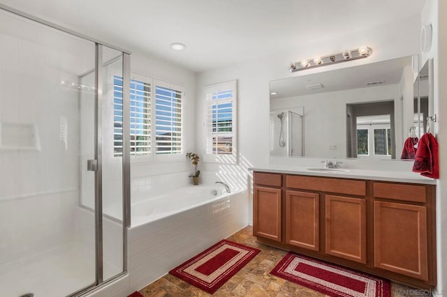 bathroom featuring vanity and independent shower and bath