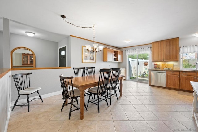 tiled dining area with sink and an inviting chandelier