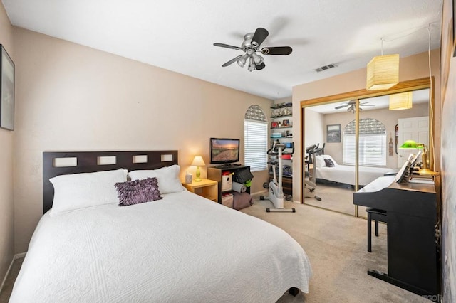 bedroom featuring light colored carpet, a closet, and ceiling fan