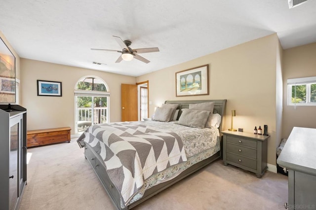 bedroom featuring ceiling fan, light colored carpet, and multiple windows