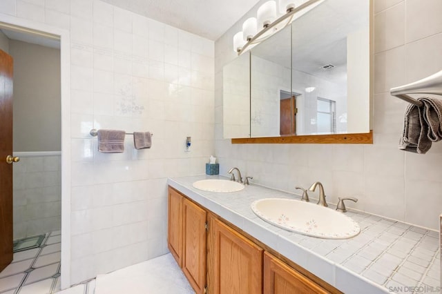 bathroom with vanity and tile walls