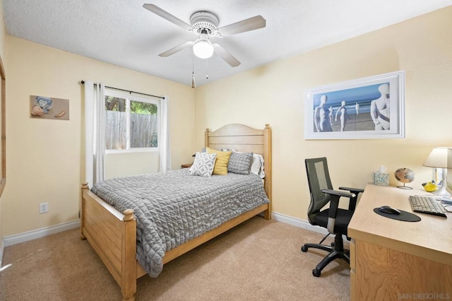 carpeted bedroom featuring ceiling fan and a textured ceiling