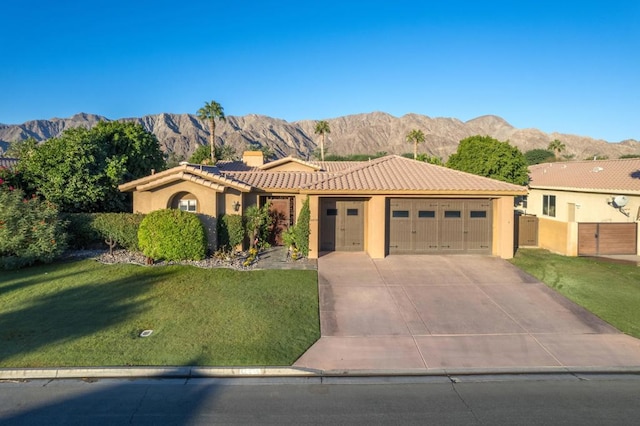 mediterranean / spanish-style home with a mountain view, a garage, and a front yard