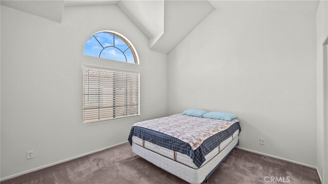 bedroom with high vaulted ceiling and carpet flooring