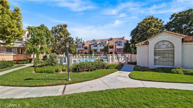 view of property's community featuring a pool and a yard