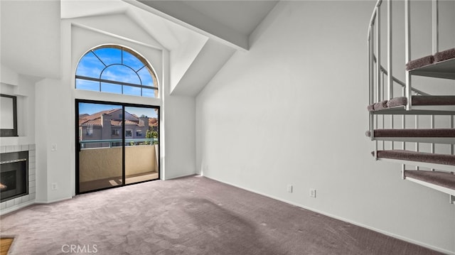 unfurnished living room featuring carpet floors and high vaulted ceiling