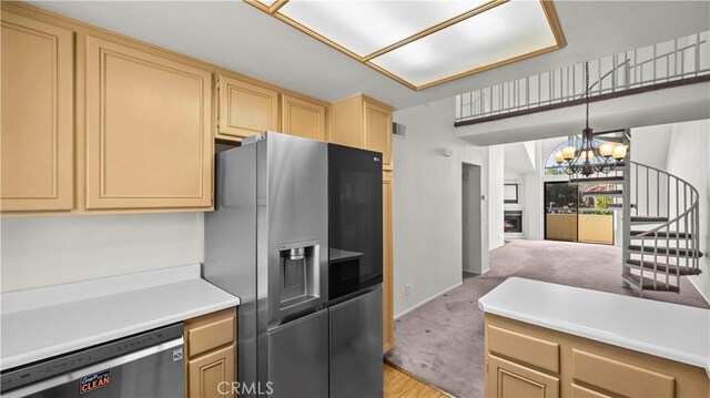 kitchen with light carpet, appliances with stainless steel finishes, light brown cabinets, decorative light fixtures, and a chandelier