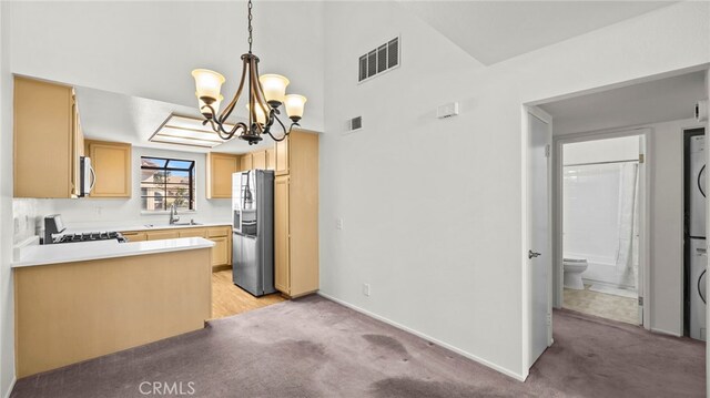 kitchen featuring light carpet, stainless steel refrigerator with ice dispenser, light brown cabinets, stove, and sink