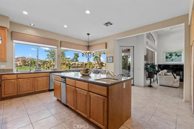 kitchen with an inviting chandelier, sink, an island with sink, decorative light fixtures, and light tile patterned flooring