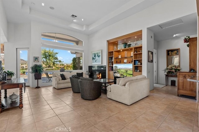 tiled living room with a raised ceiling and a high ceiling