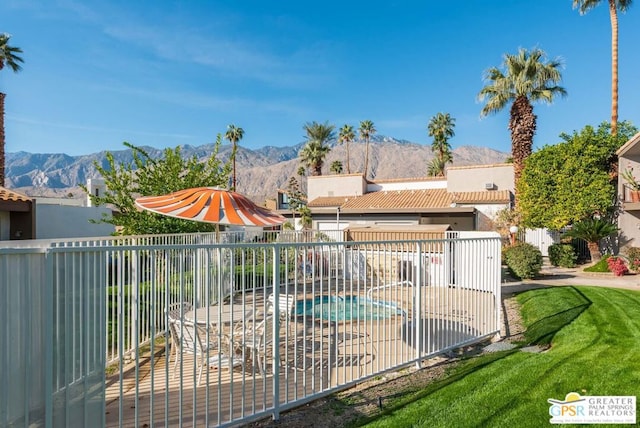 view of gate featuring a mountain view, a fenced in pool, and a patio area