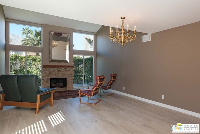 sitting room with plenty of natural light, a fireplace, and a chandelier