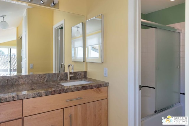 bathroom with vanity and enclosed tub / shower combo