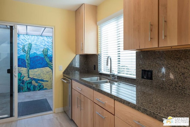 kitchen featuring sink, dishwasher, dark stone countertops, decorative backsplash, and light tile patterned flooring