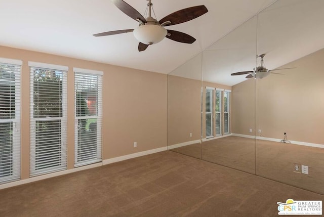 carpeted empty room with ceiling fan and lofted ceiling