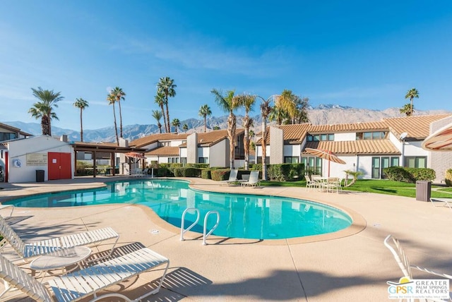 view of swimming pool with a mountain view and a patio