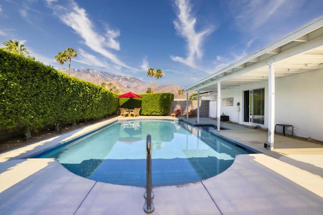 view of pool featuring a mountain view and a patio