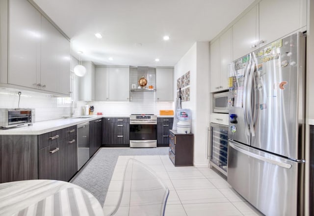 kitchen with sink, stainless steel appliances, beverage cooler, backsplash, and light tile patterned floors