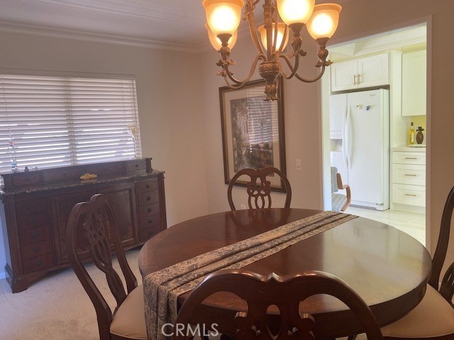 dining area featuring crown molding, an inviting chandelier, and light carpet