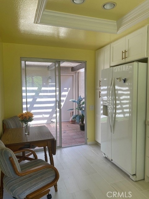 doorway with a tray ceiling and ornamental molding