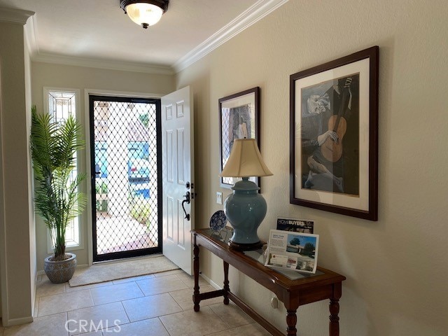 tiled foyer featuring crown molding