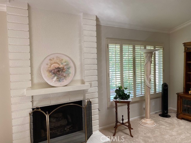 interior space featuring a brick fireplace, ornamental molding, and carpet floors