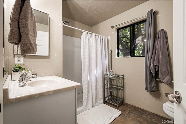 bathroom featuring a shower with curtain, vanity, toilet, and a textured ceiling