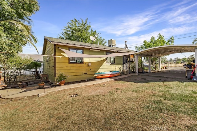 exterior space with a front yard, central air condition unit, and a carport