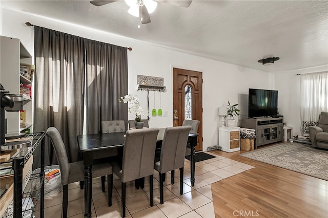 dining room with light hardwood / wood-style floors, ceiling fan, and a textured ceiling