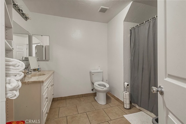 bathroom with tile patterned floors, a shower with curtain, vanity, and toilet