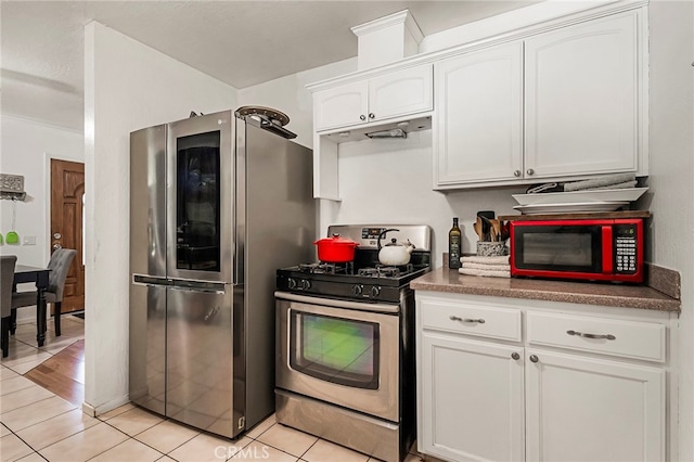 kitchen featuring white cabinets, stainless steel appliances, and light tile patterned floors