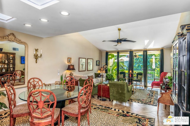 tiled dining area featuring ceiling fan, lofted ceiling with skylight, and french doors