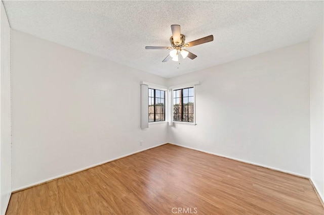 unfurnished room featuring ceiling fan, wood-type flooring, and a textured ceiling