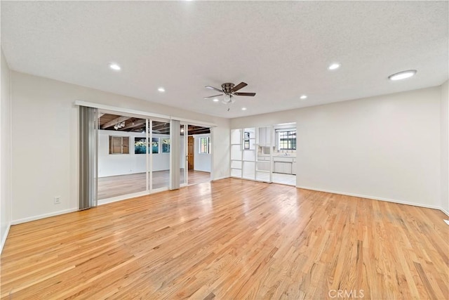 unfurnished living room featuring light hardwood / wood-style floors, a textured ceiling, and ceiling fan