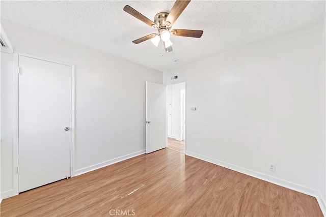 unfurnished bedroom with ceiling fan, a textured ceiling, and light wood-type flooring